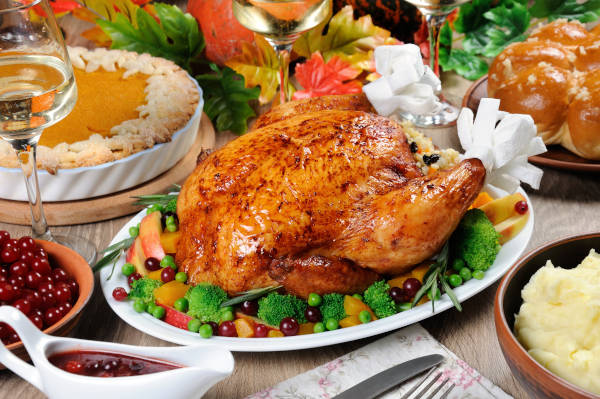 Baked turkey with vegetables, pumpkin pie, mashed potatoes, garlic buns and
cranberry-orange sauce on the table dinner on Thanksgiving Day